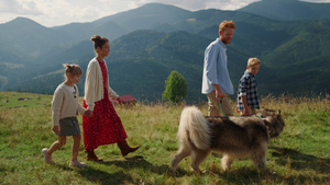 幸福的家庭在美丽的山坡上遛狗25秒视频