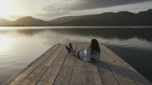 长发的年轻少女仰望着坐在湖边29秒视频