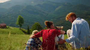 一家人坐在前山全景的青山上18秒视频