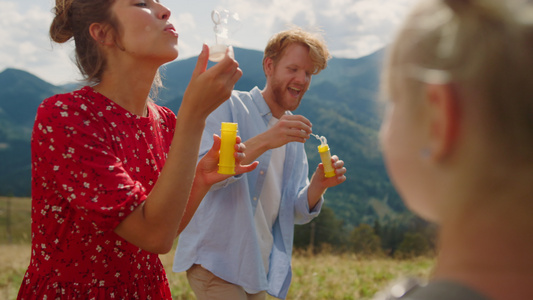 一家人在夏天的山上玩吹肥皂泡视频