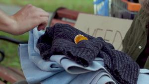 给无家可归的人取暖的衣服毛巾和药品的手12秒视频