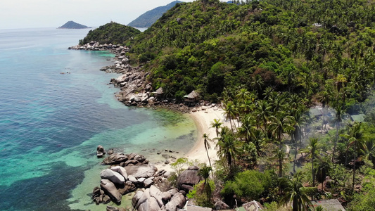 热带海滩上的平房和绿色椰子树在泰国阳光明媚的日子里视频