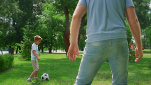 男孩与父亲特写进行足球锻炼22秒视频