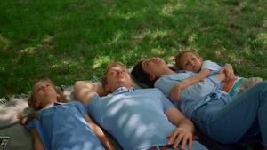 快乐的父母和孩子们躺在草地上观看11秒视频
