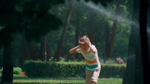 在阳光明媚的公园里快乐的孩子在跑步时洒水遮住耳朵11秒视频