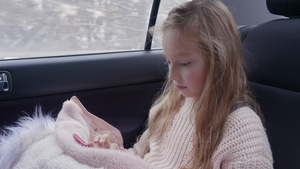 可爱的年轻女孩在互联网上上网而背后旅行时坐在车里坐16秒视频