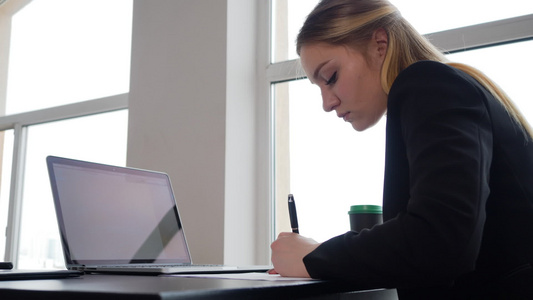 写左手商业文件的青年女创业者笔记本电脑视频
