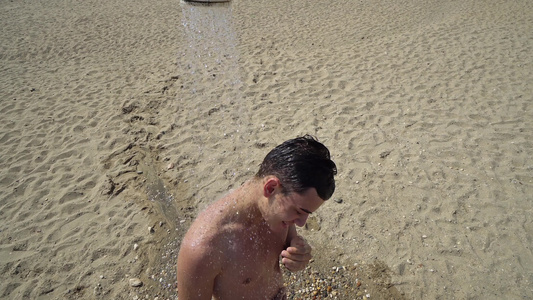 在海滩上淋浴的年轻男子视频