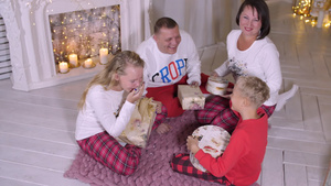 在节假日拿着圣诞礼物在壁炉附近坐着的家庭21秒视频