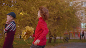 快乐的少年男孩从秋叶给公园里的年轻女孩送花束微笑的10秒视频