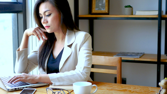 镜头忙碌的女商人与笔记本电脑一起工作早上在城市的咖啡店视频