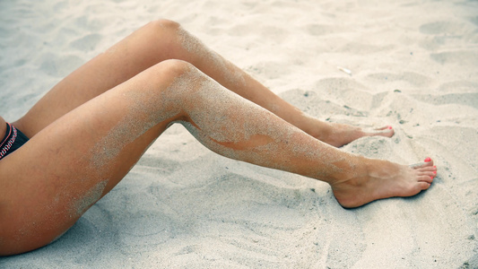 性感女性的腿在沙沙上轻轻地运动视频