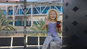 在机场出发休息室等候时坐在行李箱上欢快快乐的少女13秒视频