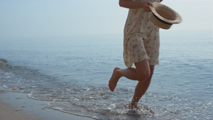 苗条的女孩运行海水拿着帽子夏日8秒视频