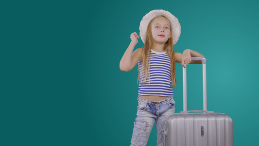 带着手提箱邀请绿色背景旅行的喜悦女孩旅行博客写博客视频