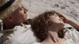 放松的女孩躺在男朋友的胸前放松在海滩上14秒视频