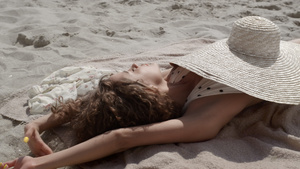 热辣的女人在海边享受阳光遮住宽边帽10秒视频
