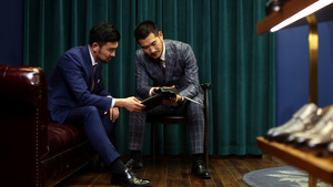 两位男士商讨选取定制服装面料12秒视频