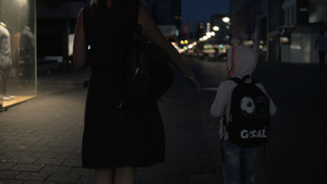 女人的慢动作幻影与儿子在夜空行人街上走来走去49秒视频