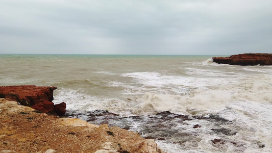 海浪来自强烈的风力冲向岩石海岸视频