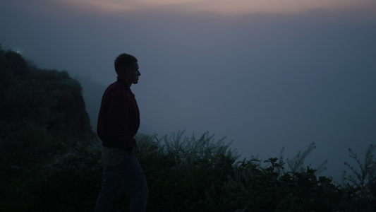 孤独的人在日出时走在山上视频