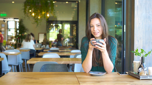 坐在户外咖啡厅喝咖啡的年轻女子14秒视频