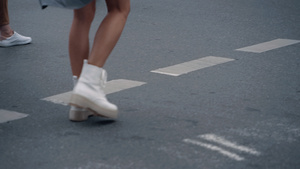 在城市背景下女人的双腿在人行横道上过马路7秒视频