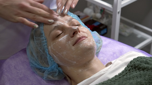 美容师把在客户脸上进行按摩运动美容手术用乳霜15秒视频
