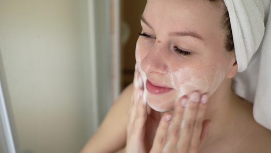 洗脸的女人在浴室用泡沫洗脸视频