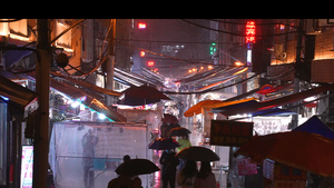城市雨天夜晚打着伞夜市购物逛街的人群4k素材60秒视频