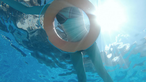 漂亮的女人在泳池里放松带着充气安全环慢动作水下风景16秒视频