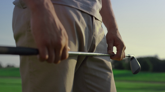 高尔夫球手手拿着推杆在日落球场上视频