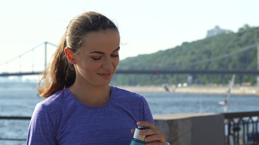 女人饮用水在美丽的风景的背面视频