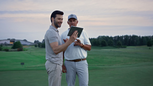 两名高尔夫球手在田野上搜索平板电脑23秒视频