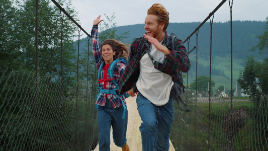 情感情侣旅行者在山桥上奔跑视频
