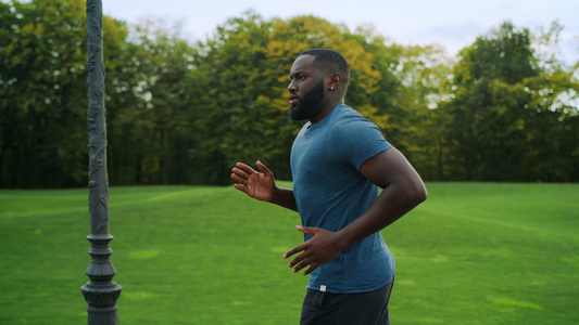 运动男子在绿色公园中慢跑视频