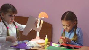 两个孩子用剪刀剪切的彩色纸剪切了两个孩子制造手工艺品22秒视频