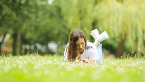 可爱女人坐在公园里时正在看手机短信的短信笑声16秒视频