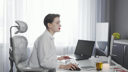 女性自由职业者在计算机工作时使用智能电话的女自由职业者视频