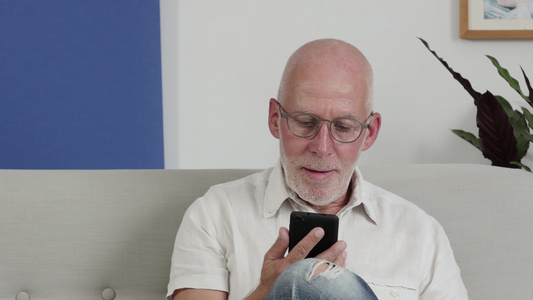 一个老人使用智能手机笑着微笑视频