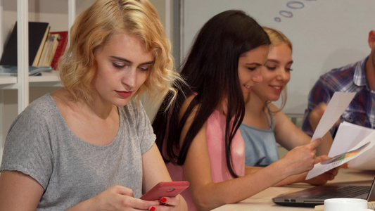 在会议期间使用智能电话的年轻女商人校对Portnoy视频