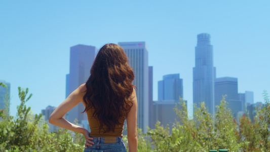 站在公园里的女人欣赏摩天大楼的景色视频