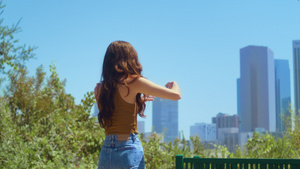 未知的黑发站在绿色公园的背影上拍照城市景观12秒视频