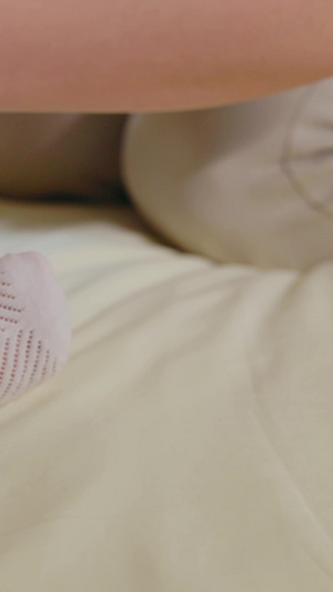 年轻妈妈给睡着的宝宝穿袜子母亲节13秒视频
