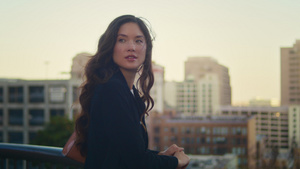 亚洲女人的肖像在栏杆附近欣赏城市景观6秒视频