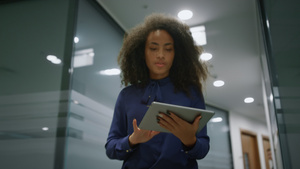 非洲裔美国女商务人士走进办公室走廊在室内浏览平板电脑30秒视频