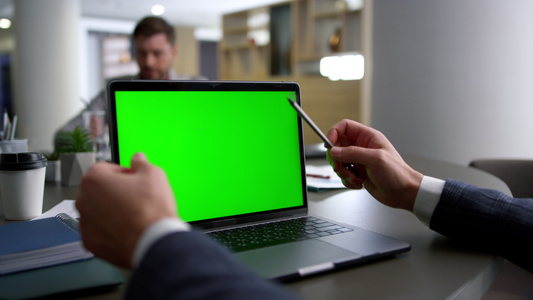商务人士手研究会议桌上的电脑笔记本绿屏视频