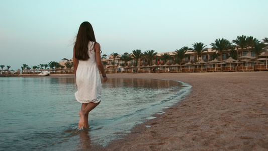 赤脚的小女孩在海边散步背影视频