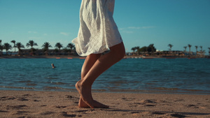 女孩在海岸沙滩上留下脚印腿部特写15秒视频