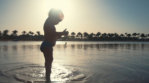 在日落海边玩水的可爱宝宝23秒视频